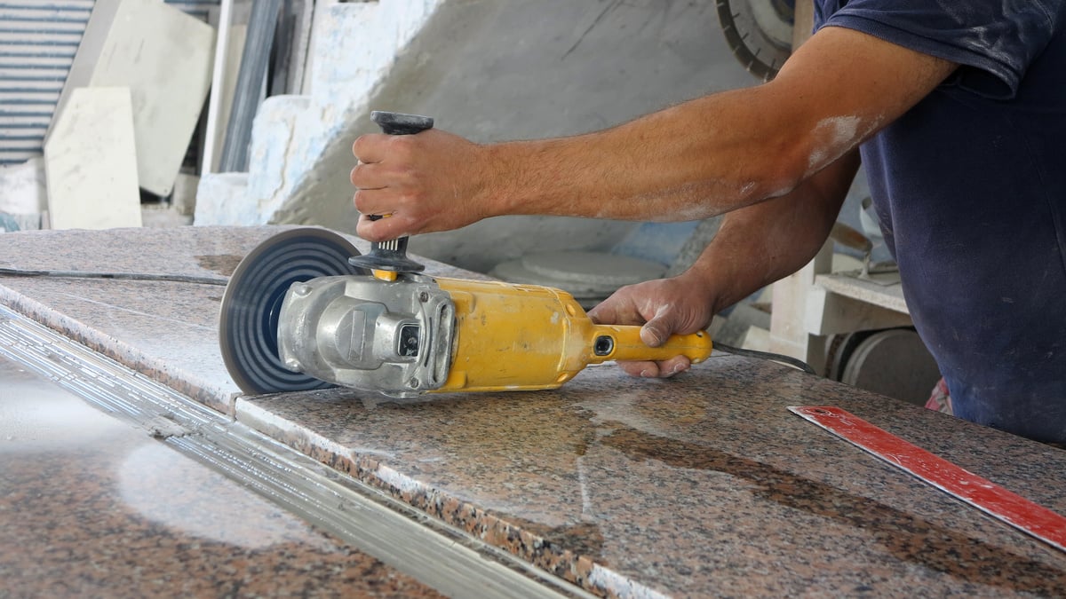 man cutting granite